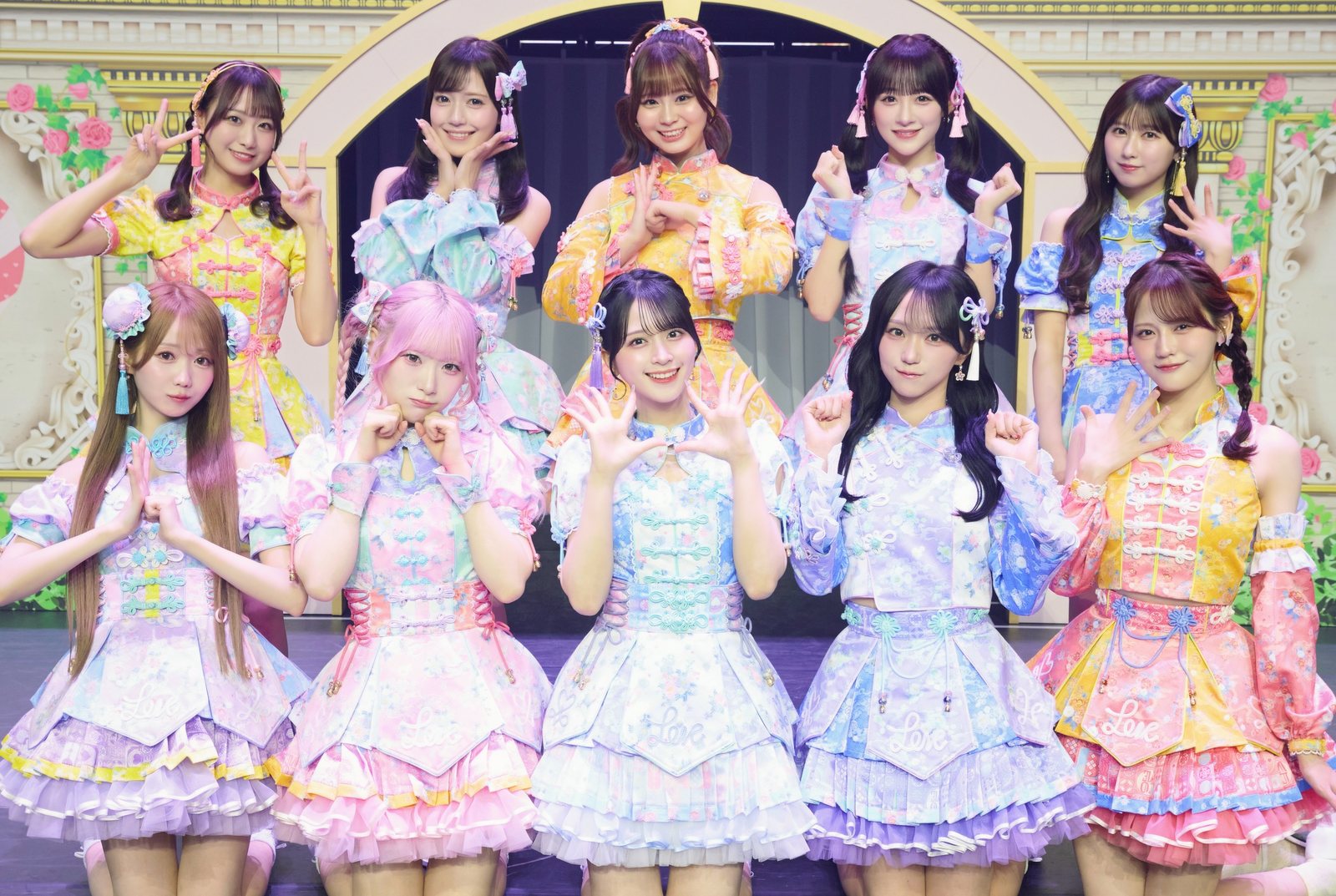 花に囲まれたセットで、パステルカラーのドレスを着た=LOVEの10人