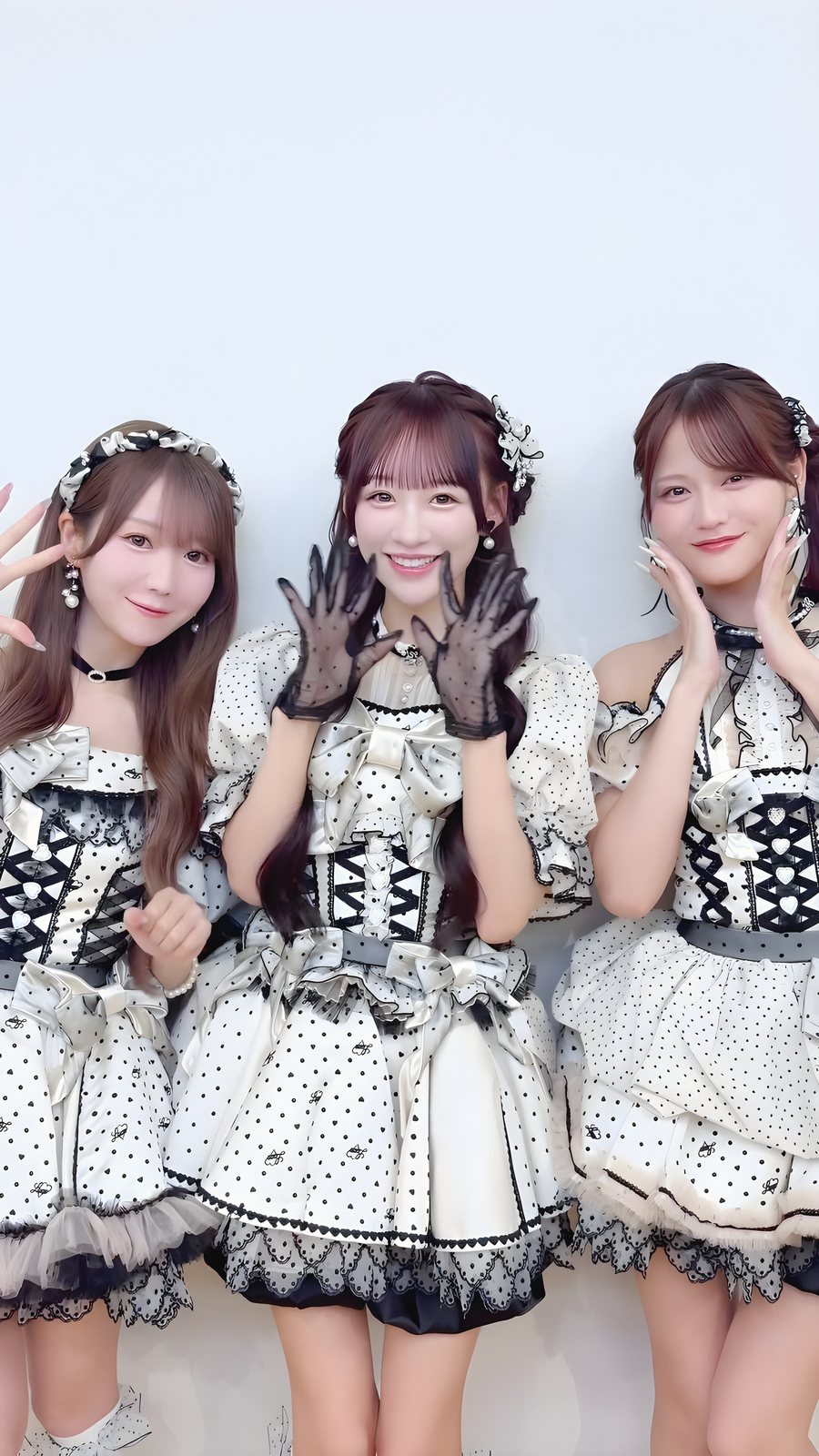 白と黒の水玉の衣装でポーズをとる3人